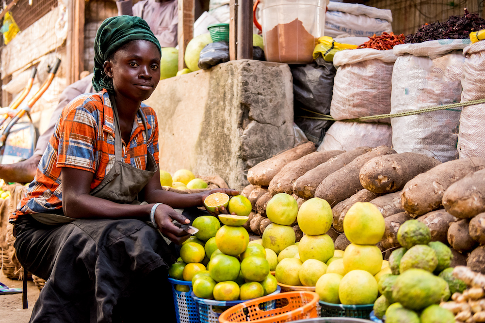 woman at market stall selling fruit